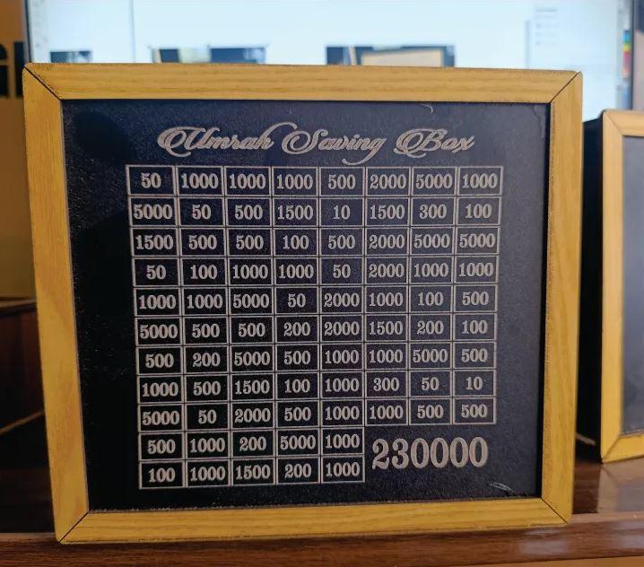 Black wooden Umrah savings box for a PKR 230,000 goal